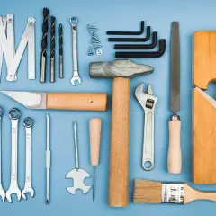 Zestaw podstawowych narzędzi hydraulika: klucze, młotek, pilnik, wiertła, śrubokręty, strug.