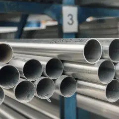 Stalowe rury ułożone w stosy, z widocznym oznaczeniem "60x12-3m", wskazującym na średnicę nominalną i długość.