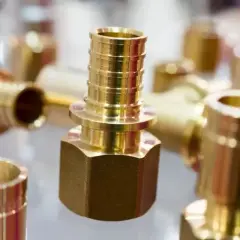 Zastosowanie mosiądzu w instalacjach hydraulicznych: błyszczące złączki i kształtki, gotowe do montażu.