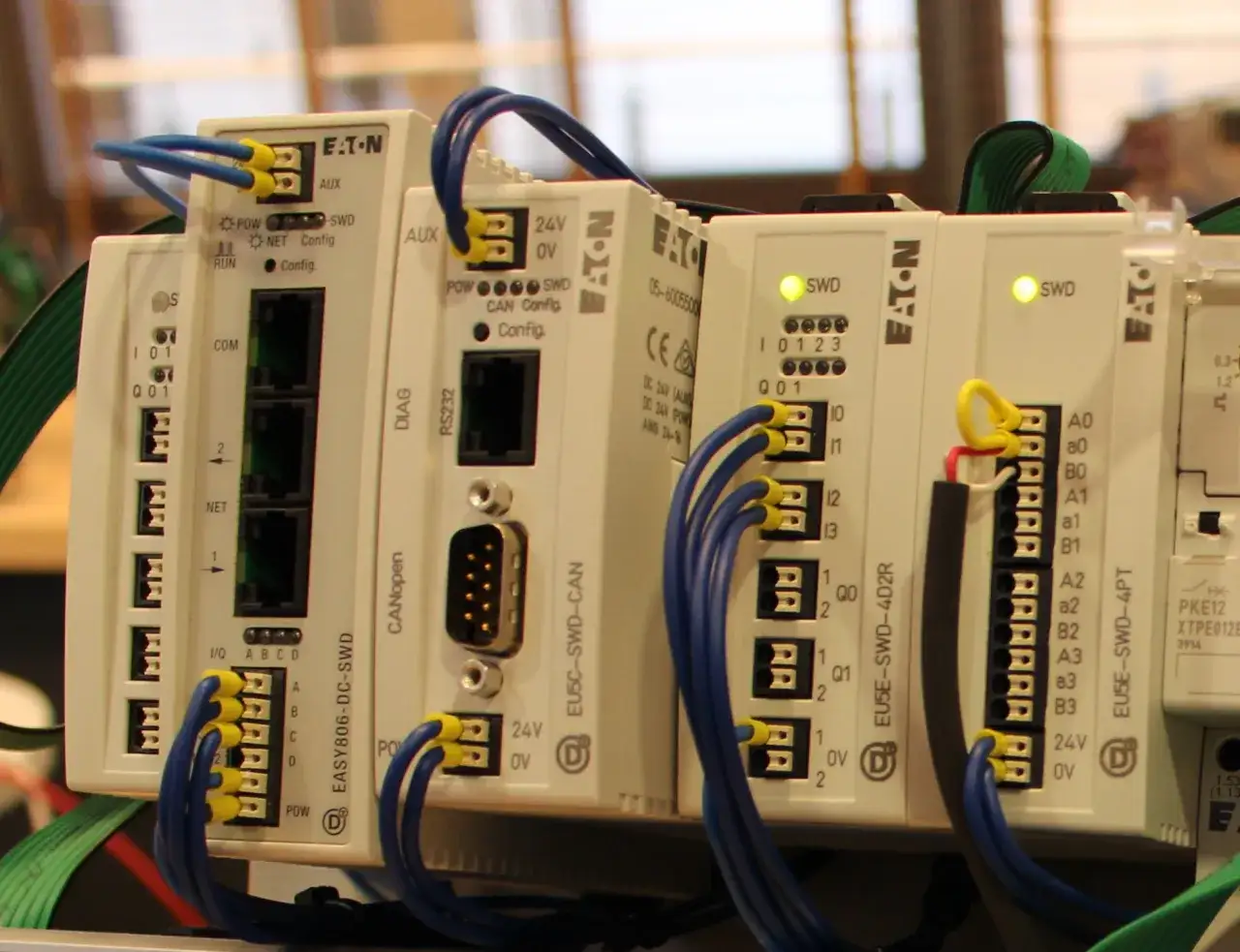 Moduły sterujące Eaton z niebieskimi przewodami. Widoczne oznaczenia: EU5C-SWD-CAN, EU5E-SWD-4D2R, EU5E-SWD-4PT.