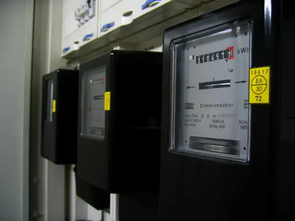 Szereg czarnych liczników energii elektrycznej, każdy z wyświetlaczem pokazującym zużycie. To jednostka mocy, która mierzy przepływ energii.