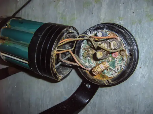 Uszkodzona instalacja elektryczna w domu, objawy: spalone przewody, skorodowane kondensatory i cewka.